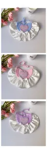 Detail of pet bib featuring heart embroidery, lace trim and satin bow in three colors