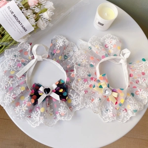 Close-up of lace pet bibs with colorful polka dots and rhinestone heart bows