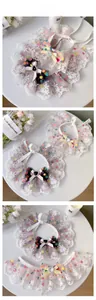 Detail of pet lace collar with polka dot bow and delicate embroidery on white mesh fabric