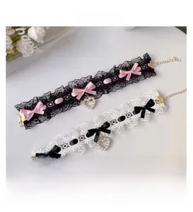 Detailed view of handmade lace pet collars with ribbon bows and pearl heart pendants