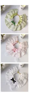 Detailed view of layered lace pet bibs with ribbon bows and heart crystal pendants