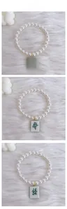 Detail display of pet pearl necklaces with red and green mahjong tile pendants
