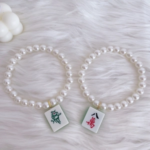 Cute pet pearl necklace with mahjong pendant on white plush background for cats and dogs