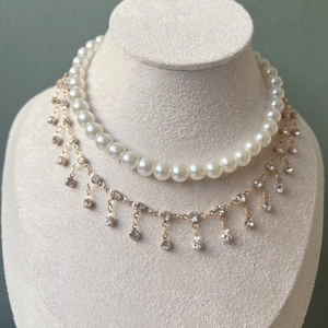 Double-layer pearl and rhinestone tassel necklace displayed on a velvet bust
