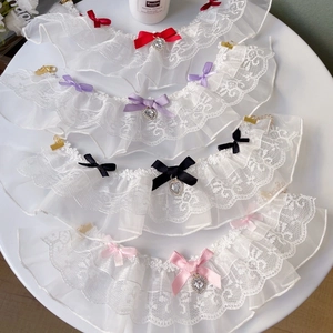 Close-up of dual-layer lace pet bibs with colorful satin bows and heart crystal pendants