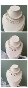 Detail of layered pet pearl necklace with rhinestone charms and gold chain on display