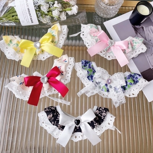 Detail of floral pet collars with lace edges, satin bows and heart rhinestone centers