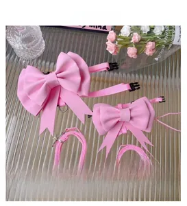 Detail of pink pet harness with large bow and adjustable buckles on rippled glass
