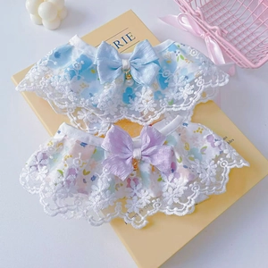 Close-up of pet lace bibs with satin bows and pearl charms in blue and purple