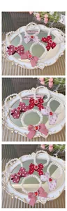 Detailed view of four pearl pet necklaces featuring large bows and red heart gems
