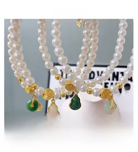Detail view of pearl pet necklaces with jade pendants and gold Fu character beads