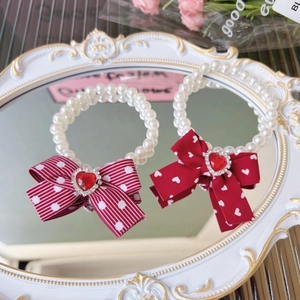 Elegant white pearl pet necklace featuring a red bow and heart-shaped red gemstone