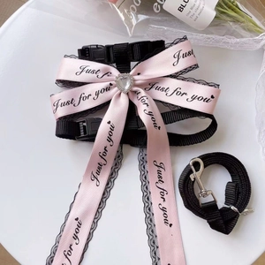 Pink lace pet harness set with bow, heart rhinestone and adjustable leash on a tray