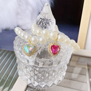 Detail of pearl pet collars with gold heart-shaped pendants in crystal and rose pink gems