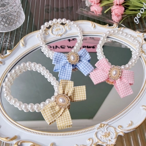 Sweet pearl pet necklace with plaid bow and rhinestone pendant on a white vintage tray
