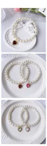 Detailed view of handmade pearl pet necklaces with heart-shaped gemstone pendants