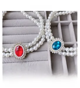 Detail of double-layer faux pearl pet necklaces with red and blue gemstone pendants