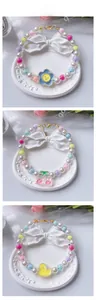 Close-up of beaded pet necklaces with cartoon flower, rabbit and duck pendants