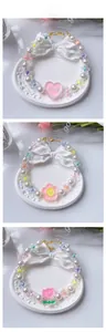 Close-up of pearl pet collars with heart and flower pendants and adjustable gold chain