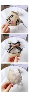Macro shot of pet straw hats with lace lace, ribbons and houndstooth bow details