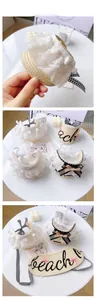Detailed view of woven straw pet hat with lace trim and beach embroidery accessories