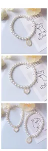 Dettaglio della collana di perle vintage per animali con ciondolo opale e cuori