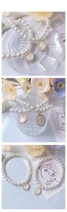 Dettaglio della collana di perle per gatti con ciondoli vintage a cuore e opale