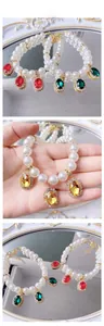 Detailed tile display of faux pearl pet necklaces with colorful gemstone pendants
