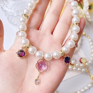 Elegante Perlenkette für Haustiere mit rosa Herzkristall-Anhänger in der Handfläche