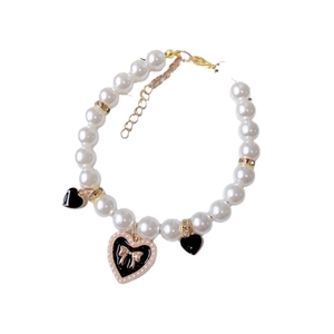 Elegant pet pearl necklace with black heart charms and golden bow detail for cats and dogs