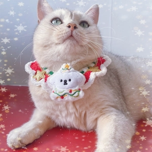 Detail of hand-knitted Christmas pet collar with white tree and stars on a cat