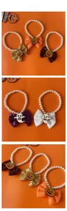 Detail view of Halloween pet pearl collars with pumpkin ghost bows and sequins