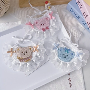 Detailed view of handmade crochet pet bibs with lace edges and cute bear patches