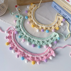 Handmade knitted cat and dog collars with colorful pom-poms in pastel cream colors