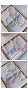 Detailed tile display of handmade pearl pet necklaces with colorful resin flower charms