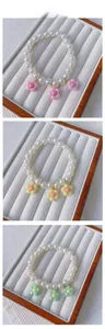 Detailed view of handmade beaded pet collars with pearls and colorful resin flower charms