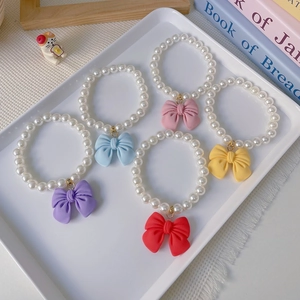 Detailed view of colorful bow pendants on elegant pearl necklaces for cats and dogs