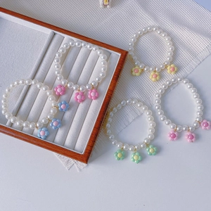 Set of five handmade pearl bracelets with colorful macaron flower charms and elastic cord