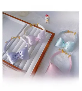 Detail of pet bow collars with heart gems and adjustable gold chains in varied colors