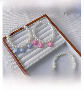 Detailed macro view of handmade pearl pet necklaces featuring colorful resin flower charms