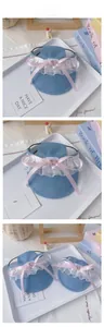 Détail d'un chapeau en denim pour animal avec dentelle blanche, nœud rose et sangle réglable