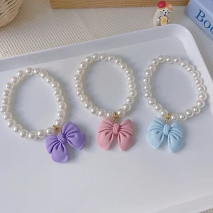 Cute bow and pearl pet necklace for cats and dogs in purple, pink, and blue colors