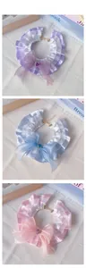 Detail of pet lace collar with double ruffles, large ribbon bow, and heart-shaped gem