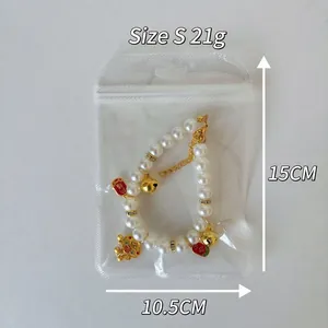 Size S pearl pet necklace with golden bells and red lucky charms on white background