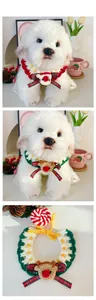 Detail of hand-knitted Christmas pet collar with cartoon reindeer and plaid bow decoration