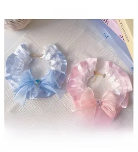Detail showing lace ruffle pet collars with ribbon bows and heart-shaped gems