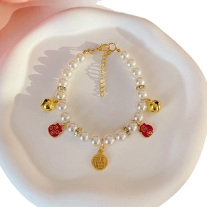 Chinese style pet pearl necklace with gold fortune lock pendant and bells on tray