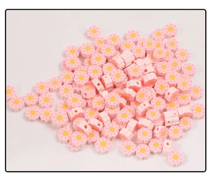 Détail des perles fleurs en pâte polymère rose pour la création de bijoux DIY