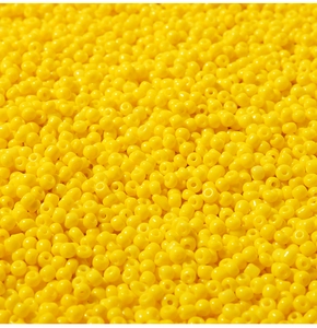 Dettaglio macro di perline gialle lucide per la creazione di gioielli e braccialetti