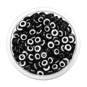 Vue macro de perles plates œil maléfique en acrylique noir et blanc dans leur boîte